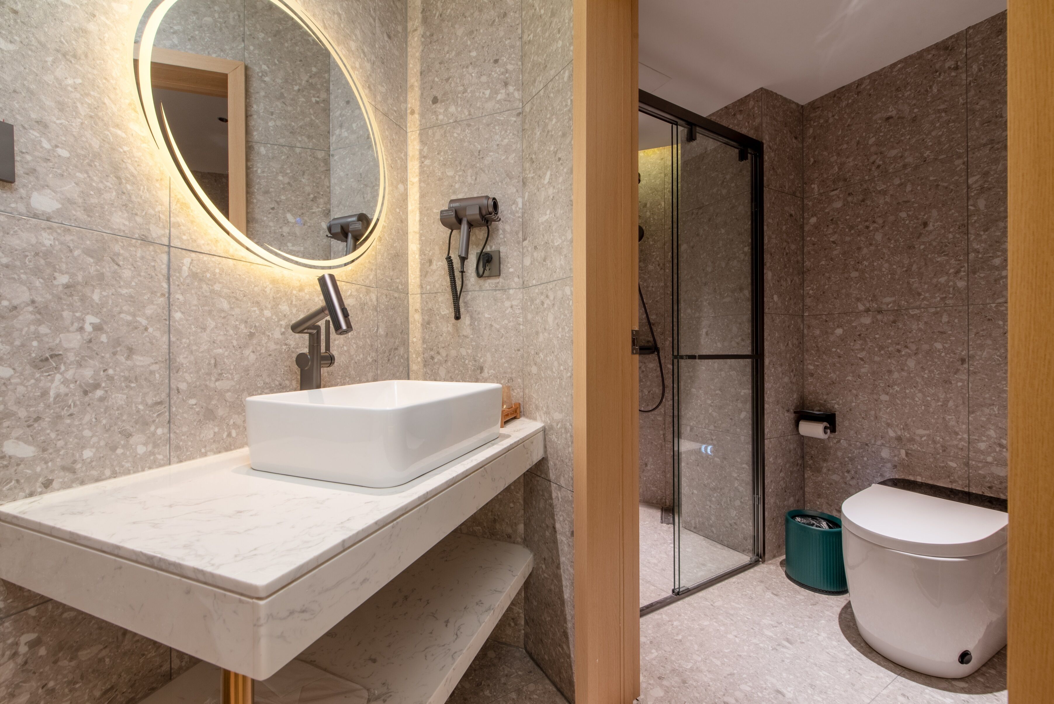 A bathroom with a white sink, mirror, and shower.