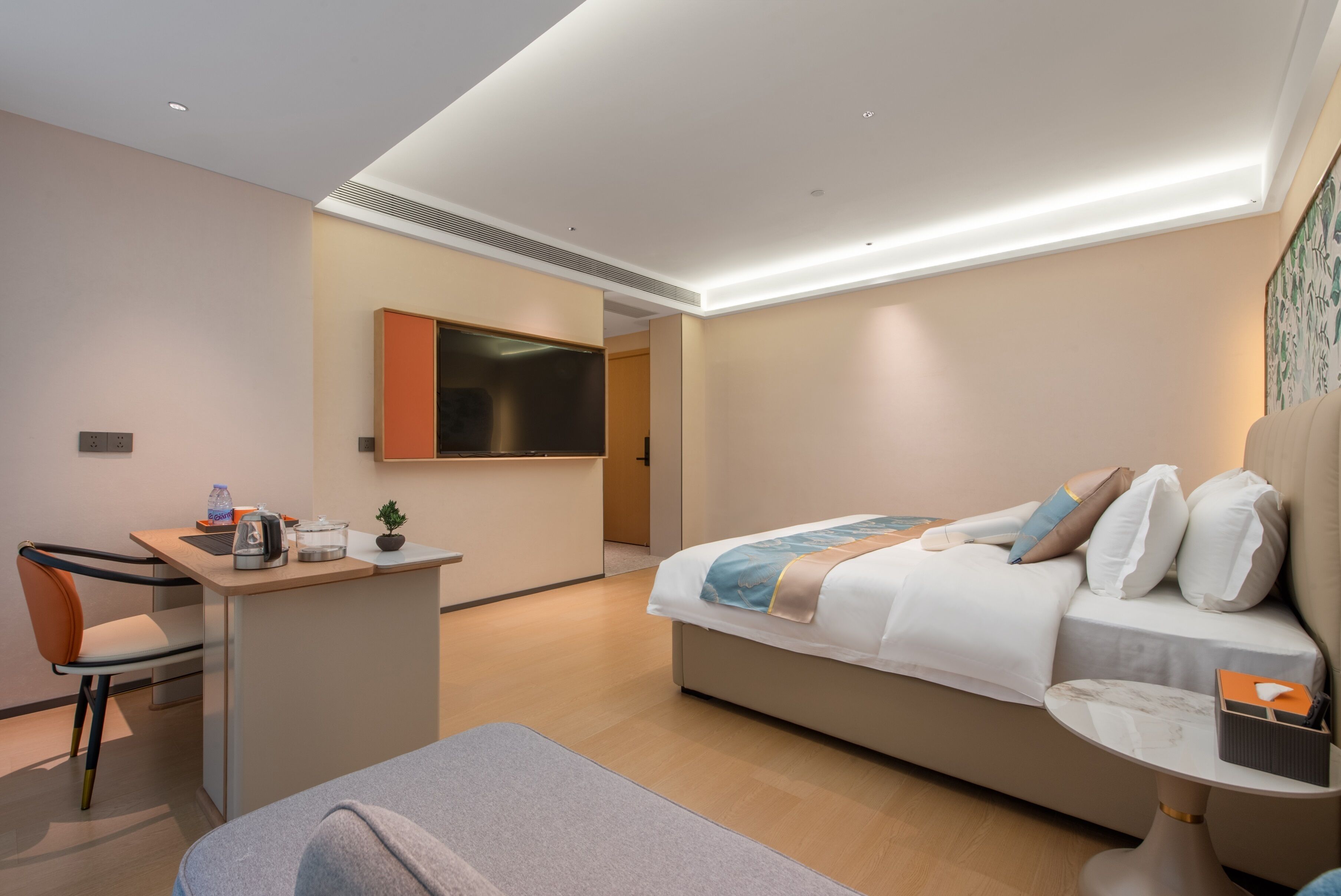 Una habitación de hotel moderna con cama, escritorio, silla y una mesita.