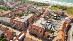 A coastal town with traditional red-roofed buildings, a beach, and a pier. - Apartment in Zoutelande Near Sunny Beach (Zoutelande)