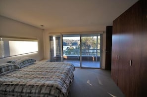 Una camera da letto con un letto, un armadio e un balcone con vista.