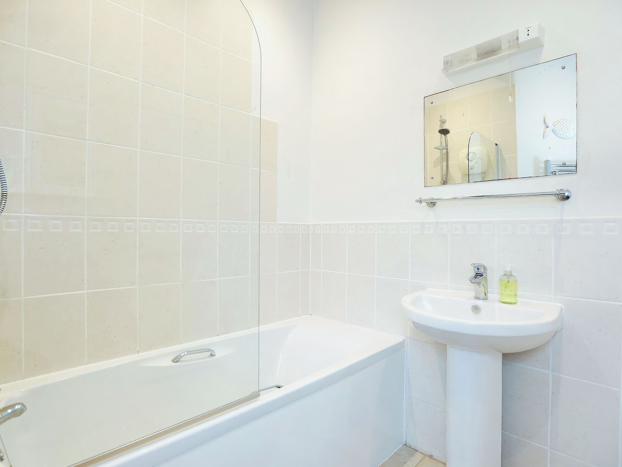 Un baño con bañera, lavabo y espejo.