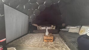 Ein gemütliches Wohnzimmer mit einer Couch, einem Couchtisch und einem einzigartigen Deckenstil.
