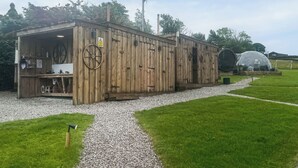 Ein hölzernes Gebäude mit Wasserrad, einem Schild und einem Weg davor.