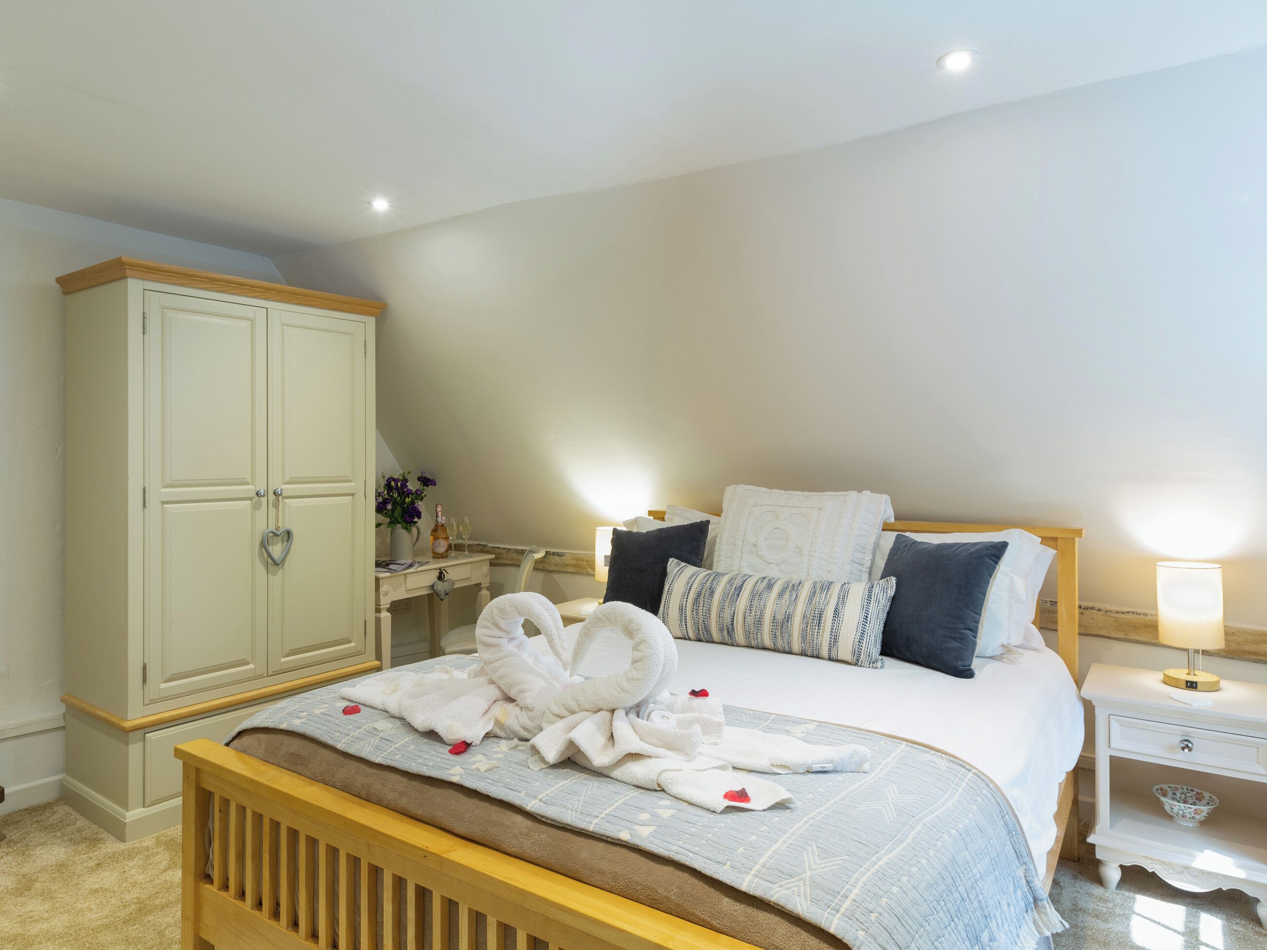 A bedroom with a bed, nightstands, a dresser, and a lamp.