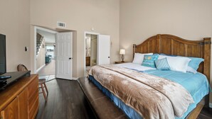 A bedroom with a bed, a desk, a chair, a ceiling fan, and a door leading to a balcony. - Fishing on the Overwater Balcony! 2BR/2BA Condo with Beautiful Lake Conroe View (Willis)