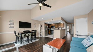 A modern living room with a dining area, a kitchen, and a ceiling fan. - Fishing on the Overwater Balcony! 2BR/2BA Condo with Beautiful Lake Conroe View (Willis)