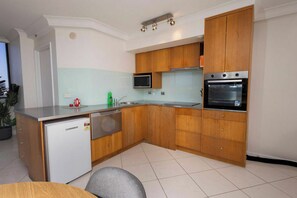 Una cocina moderna con armarios de madera, microondas integrado y horno.