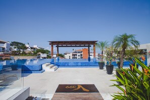 A rooftop pool area with a pergola, palm trees, and a clear sky. - Modern V399 Studio | Walk to Beach, Dining & Night 1BD Condo for rent in Old Tow (Puerto Vallarta)