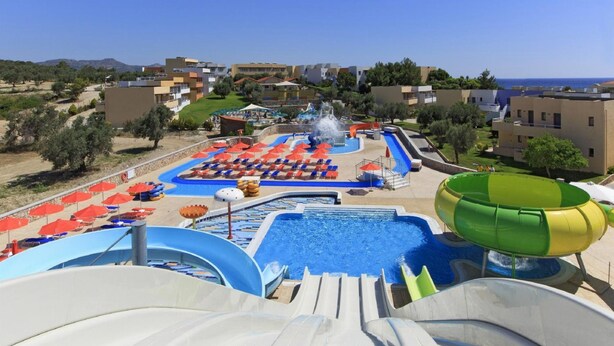 A water park with slides, a pool, and lounge chairs. - Villa Daphne in Inverness (Rhodes)