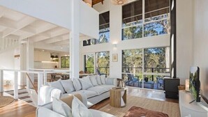 A spacious living area with a large sofa set, a coffee table, and a fireplace. - Maisie's by Holiday Management Co. (Bega Valley)