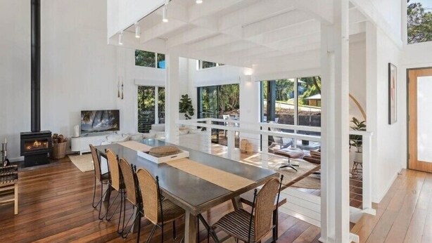 A spacious dining area with a long table, chairs, and a fireplace. - Maisie's by Holiday Management Co. (Bega Valley)