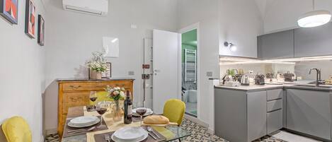 Una cocina moderna con zona de comedor, que incluye una isla de cocina, una mesa de comedor con sillas y un horno empotrado.