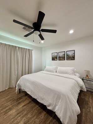 A bedroom with a bed, a ceiling fan, a window with curtains, and three framed pictures on the wall. - Downtown Phoenix Home w/ Pool- Near Airport! (Phoenix)
