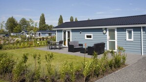 A single-story house with a patio area, outdoor seating, and a garden. - Holiday Home in Nijkerk With Terrace (Nijkerk)