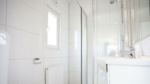 A modern bathroom with a toilet, a shower enclosure, and a sink. - Holiday Home in Nijkerk With Terrace (Nijkerk)