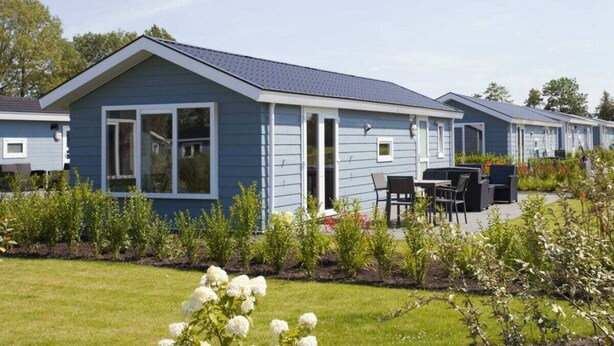 A blue mobile home with a patio area, a small garden, and a clear sky. - Holiday Home in Nijkerk With Terrace (Nijkerk)
