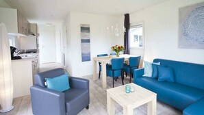 A modern living room with a sofa, chairs, a coffee table, and a dining area with a table and chairs. - Holiday Home in Nijkerk With Terrace (Nijkerk)