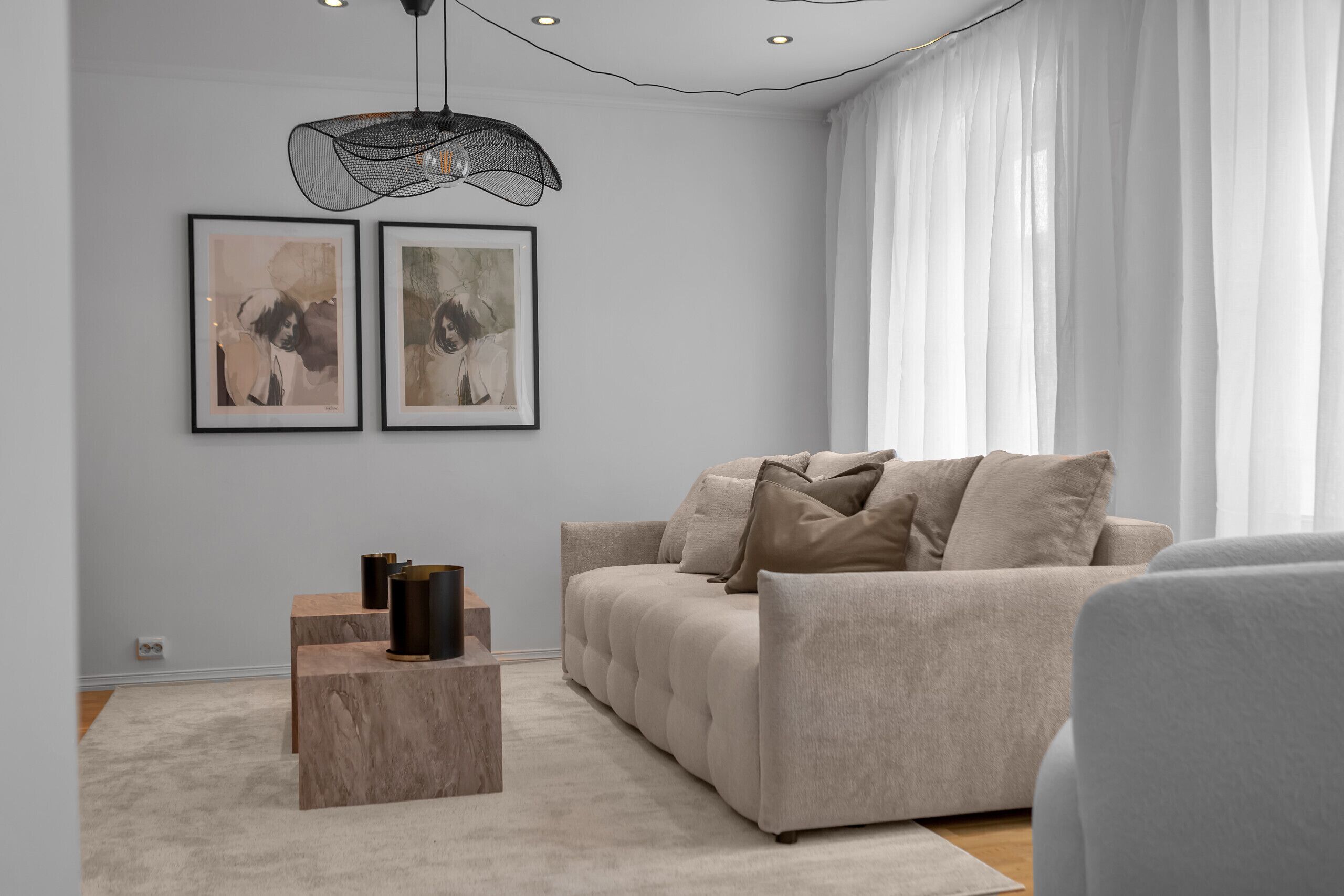 A modern living room with a sofa, a coffee table, and artwork on the wall.