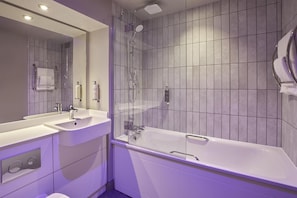 Un baño moderno con bañera, dos lavamanos, ducha y un espejo grande.
