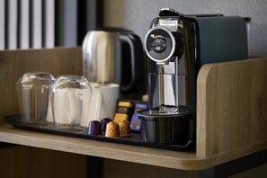 A coffee machine on a wooden counter with a tray of glasses and containers. - Premier Inn Manchester City Centre - Northern Quarter (Manchester)