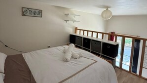 Ein Schlafzimmer mit einem Bett, einem Nachttisch, einem Wandregal und einem Fenster mit Blick.