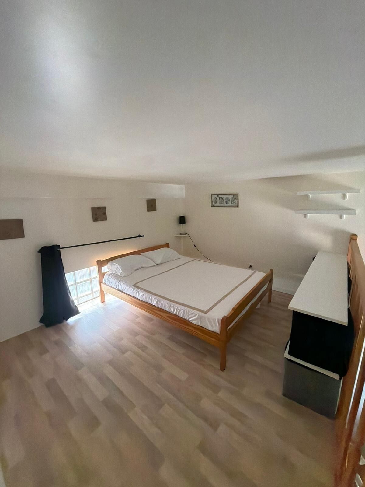 A bedroom with a wooden bed, a desk, and a chair.