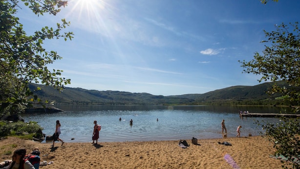 Un lac où l’on peut se baigner et se promener le long de la rive, entouré de collines.