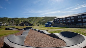 Un parc à skate avec des rampes et un bâtiment en arrière-plan.