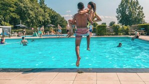 A swimming pool with people enjoying the water, surrounded by trees and a clear sky. - Holiday Home in Dordrecht With Terrace (Dordrecht)
