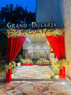 An entrance with a red curtain, floral decorations, and a sign reading 'GRAND DULARIA'. - Grand Dularia (Nagpur)