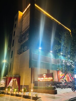 A hotel with a prominent sign, a covered entrance, and a parking area with motorcycles. - Grand Dularia (Nagpur)