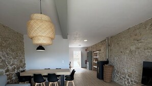 Ein modernes Wohnzimmer mit Essbereich, einer Couch, einem Fernseher und einer Steinwand.