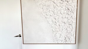 Una porta bianca con un pannello a rilievo e un pavimento rivestito di moquette scura.