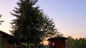 A pathway leading to a red structure, surrounded by greenery and a building in the background. - Casa Lilla - House with Garden near Venice (Veneto)