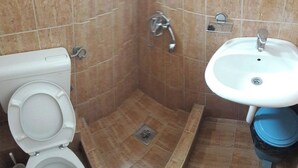 A bathroom with a toilet, shower, and sink. - Trokrevetni partman sa svojim kupatilom, terasom i parkingom u dvoristu kuce. (Budva)