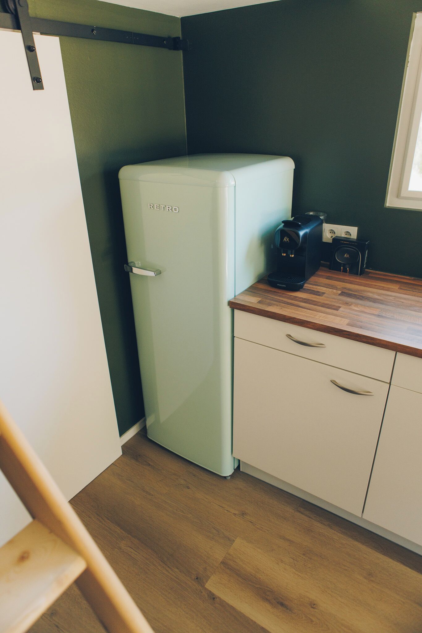 Una cocina con un refrigerador de estilo retro, una cafetera y una encimera de madera.
