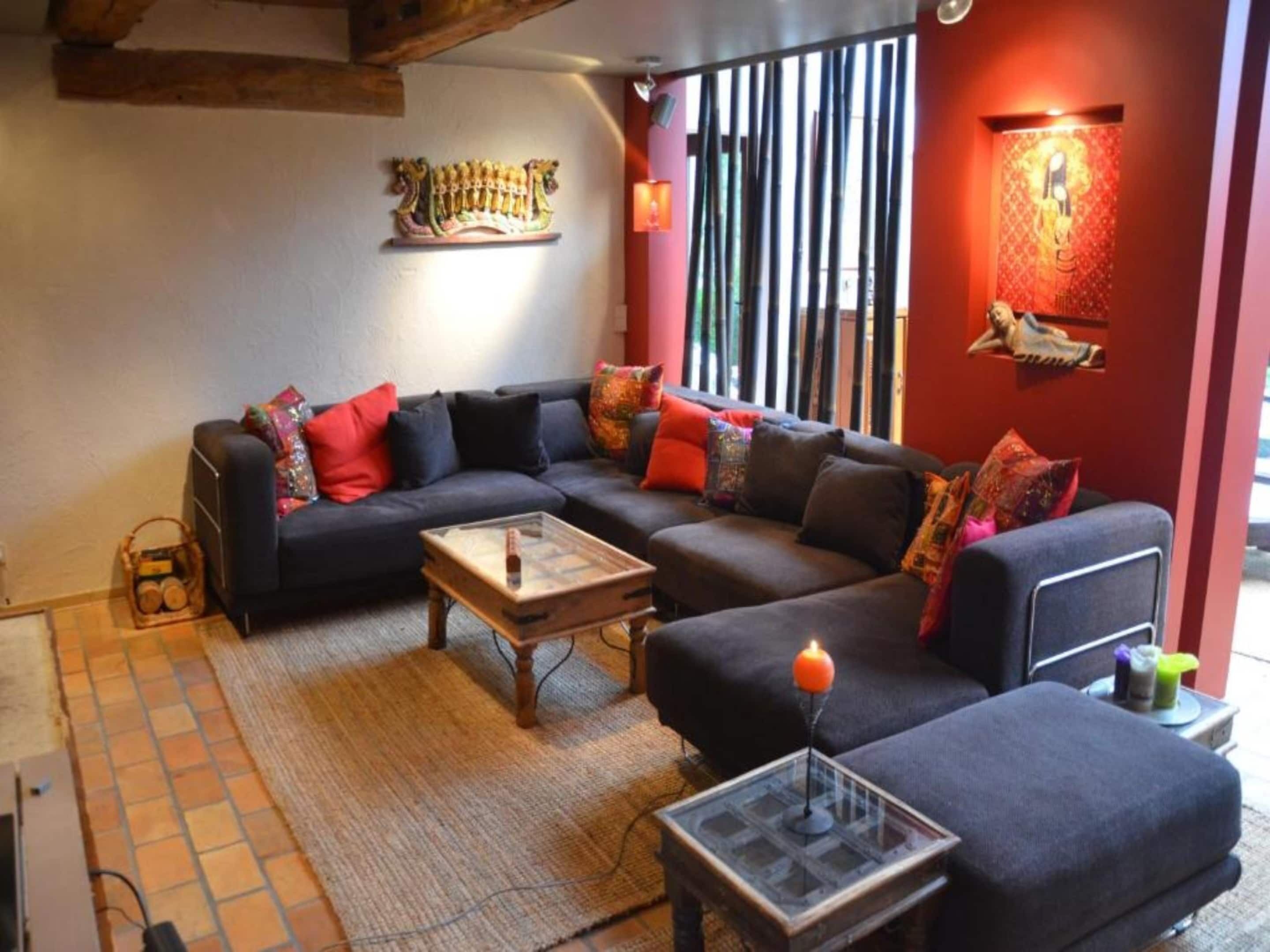 A modern living room with a sectional sofa, a coffee table, and a decorative wall piece.