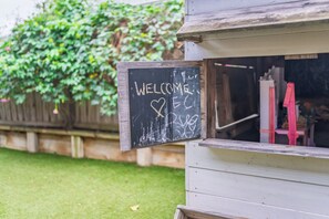 Una estructura de madera con un letrero que dice 'WELCOME' y un símbolo de corazón.