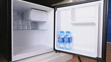 An open refrigerator with two water bottles on the door shelf and a glass container on the upper shelf.