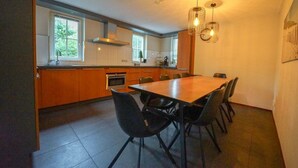 Una cocina moderna con zona de comedor, ventanas amplias y un ventilador de techo.