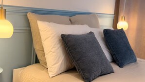 A bed with a headboard, pillows, and bedside lamps. - L'Échappée Malouine: Beach 3 min away + Private courtyard (Dunkerque)