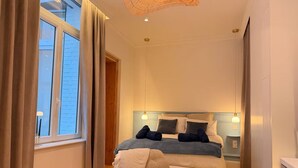 A bedroom with a bed, bedside tables, a chair, and a window. - L'Échappée Malouine: Beach 3 min away + Private courtyard (Dunkerque)