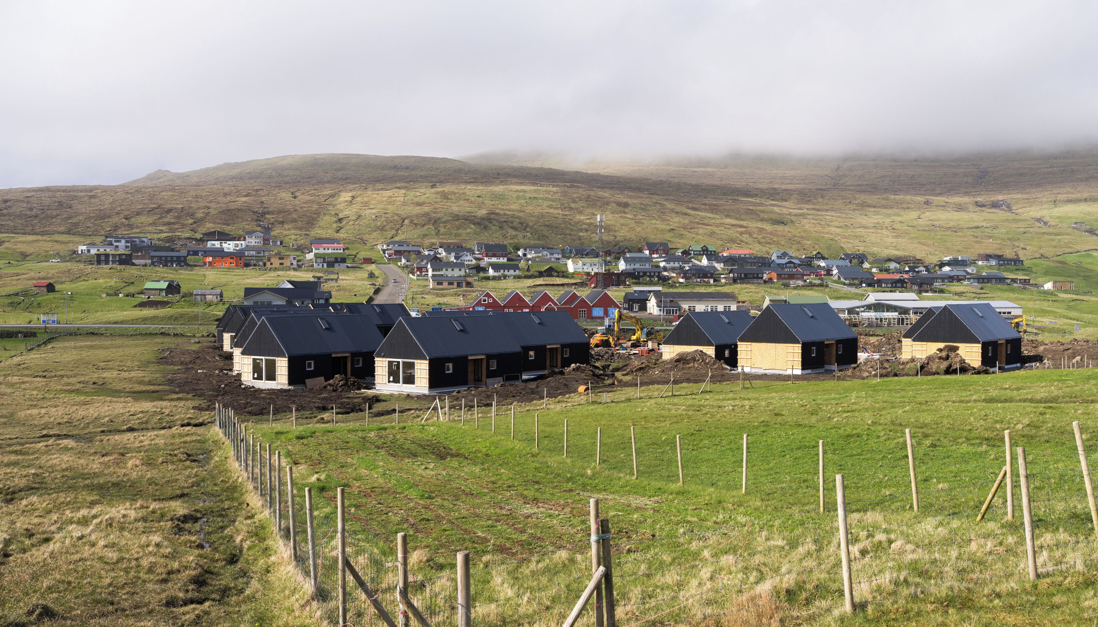 Paisaje rural con casas, una obra en construcción y una carretera.