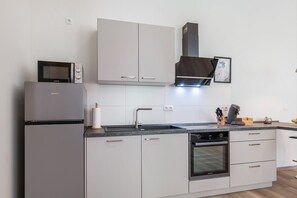 A modern kitchen with a built-in oven, a microwave, and a coffee machine. - Isenach Apartment – Quiet Location in Hardenburg (Bad Dürkheim)