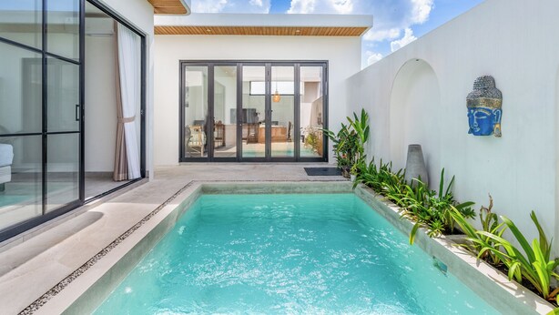A modern pool area with glass doors, a pool, and a view of the interior. - VILLA TRATASAN CANGGU (Badung)