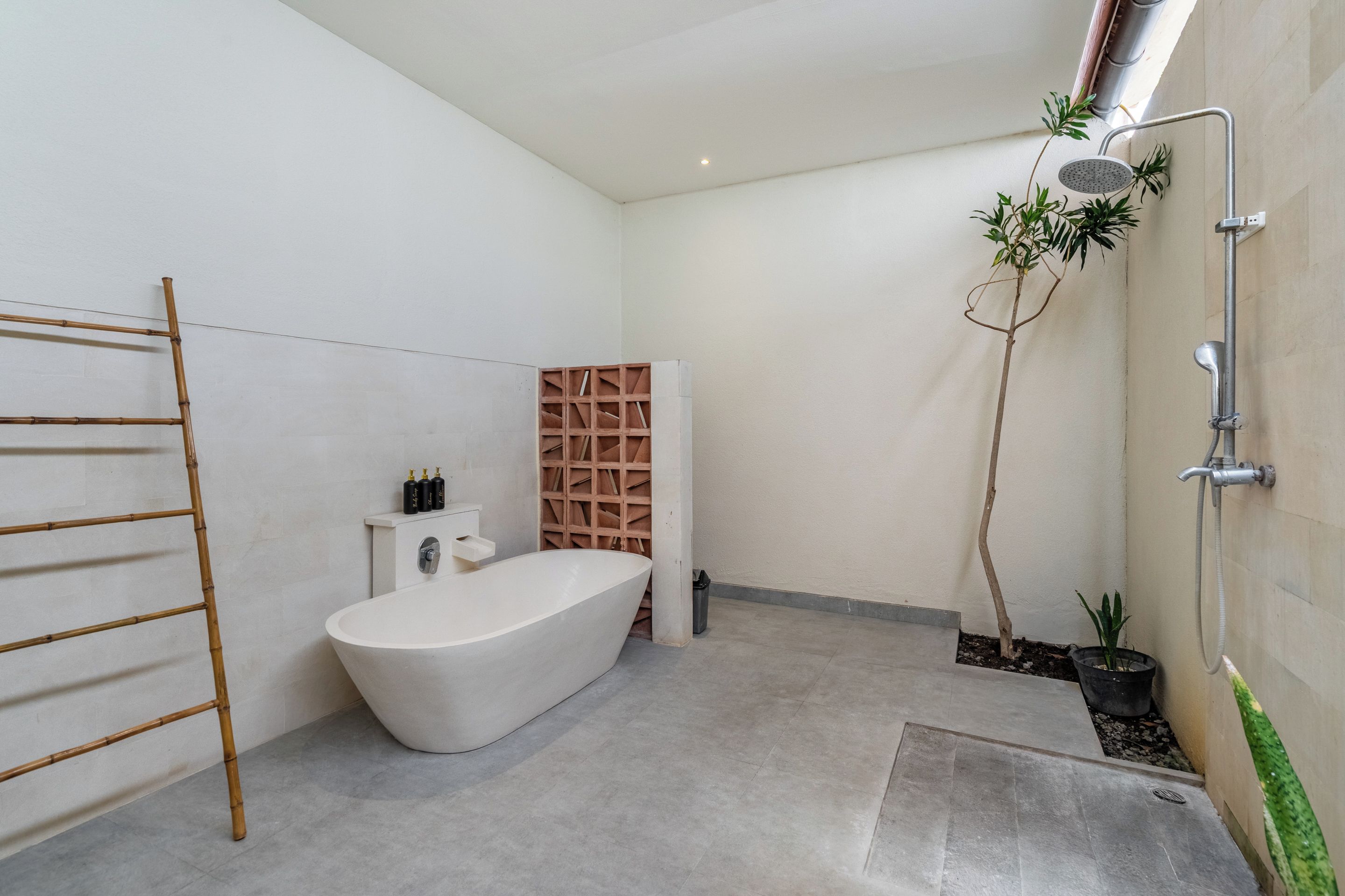 Een moderne badkamer met een vrijstaand bad, een douche en een bamboe ladder.