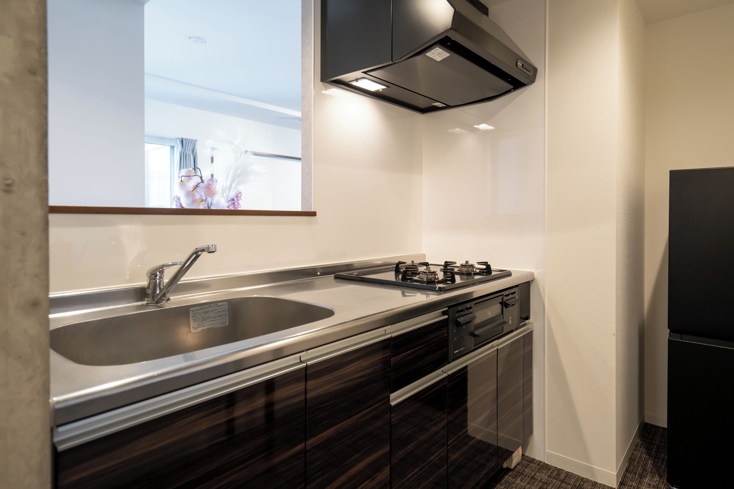 Una cocina moderna con un lavamanos de acero inoxidable, una estufa a gas y un horno empotrado.