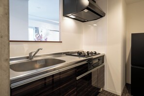 Una cocina moderna con un lavamanos de acero inoxidable, una estufa a gas y un horno empotrado.