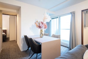 A hotel room with a dining area, a bed, and a large window with curtains. - Hotel Luxe HIRAGISHI (Sapporo-shi)