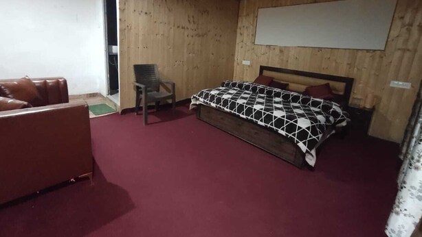 Una habitación con una cama, una silla y un sofá.